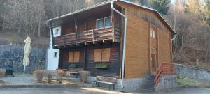 a large wooden house with a balcony and a bench at Penzion Svojanov in Svojanov
