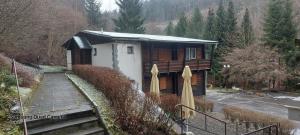 a wooden cabin with a parking lot and a fence at Penzion Svojanov in Svojanov