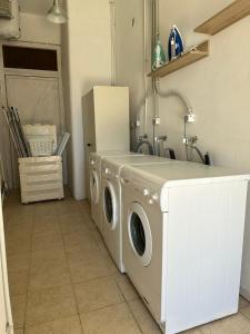 una lavanderia con lavatrice e asciugatrice di ēnNĒ Studios for Views & Tranquility a Ftelia