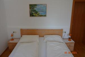 ein Schlafzimmer mit 2 Betten und einem Bild an der Wand in der Unterkunft Villa Vidal in Niederdorf