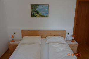 a bedroom with two beds and a picture on the wall at Villa Vidal in Villabassa