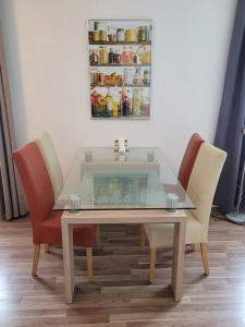 a dining room table with two chairs and a refrigerator at Zentral gelegene, sehr ruhige und helle Wohnung in Graz