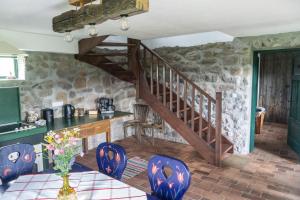 eine Küche mit Treppe und Tisch und Stühlen in der Unterkunft Hillside View Cottage - Csíksomlyó-panoráma vendégház in Păuleni-Ciuc