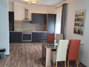 kuchnia ze szklanym stołem i czerwonymi krzesłami w obiekcie Zentral gelegene, sehr ruhige und helle Wohnung w Grazu