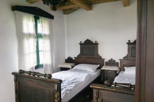 a bedroom with two twin beds and two windows at Hillside View Cottage - Csíksomlyó-panoráma vendégház in Păuleni-Ciuc