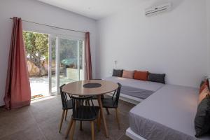 a room with a bed and a table and a bed at Prasino Oniro in Tinos