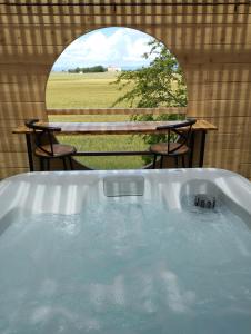 een hot tub in een tent met een tafel en stoelen bij Le Spa panoramique du plateau in Valensole