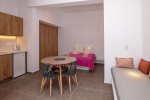 Habitación pequeña con cama, mesa y sillas en Prasino Oniro en Tinos Town