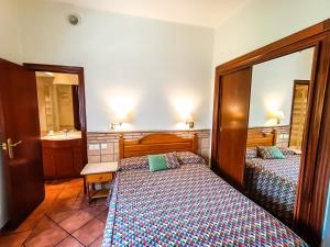 a bedroom with two beds and a sink and a mirror at Hotel Can Solé in Cambrils