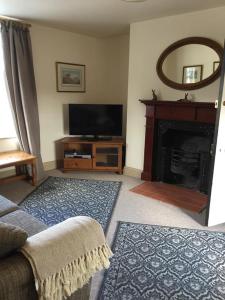 a living room with a television and a fireplace at The Crown Inn Smallburgh in Smallburgh