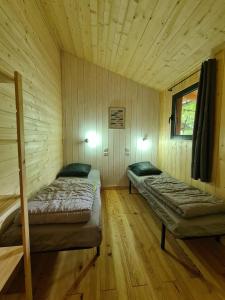 a room with two beds in a wooden cabin at Camping Aux Couleurs du ferret in Lège-Cap-Ferret