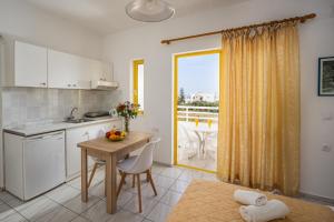 a kitchen with a table and a table and a window at Cosmi Apts Gouves by Estia in Gouves