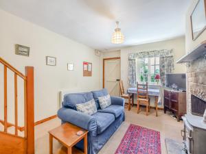 a living room with a blue couch and a table at Coachmans Cottage - N832 in Wark