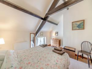 a bedroom with a large bed and a chair at Coachmans Cottage - N832 in Wark
