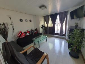 ein Wohnzimmer mit einem Sofa und einem Glastisch in der Unterkunft NancyRoom in Vandoeuvre-lès-Nancy