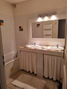 uma casa de banho com 2 lavatórios e um espelho em Villa avec vue sur Sommières em Villevieille