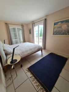 um quarto com uma cama, uma cadeira e um tapete azul em Villa avec vue sur Sommières em Villevieille