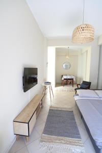 a living room with a bed and a tv at Rhodes Town Garden Apartment in Rhodes Town