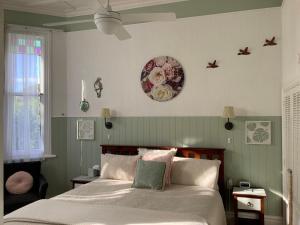 een slaapkamer met een bed en een klok aan de muur bij Chelsea House Bed & Breakfast in Whangarei