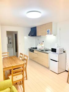 a kitchen and dining room with a table and a microwave at ＊大阪＊一棟貸切、駅から徒歩3分、複数駅利用可、電車で梅田まで5分、地下鉄でなんばまで9分 in Osaka