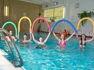 a group of children playing in a swimming pool at Hotel SOREA ĽUBOVŇA in Stará Ľubovňa