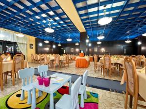 ein Esszimmer mit Tischen, Stühlen und blauen Decken in der Unterkunft Hotel SOREA ĽUBOVŇA in Stará L'ubovňa