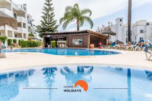 una piscina in un resort con un hotel con le parole "vacanze casalinghe" di #166 Old Town, 600 mts Beach with Pool ad Albufeira