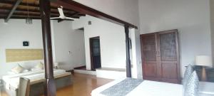 a bedroom with a bed and a wooden door at Kaya Residence Kandy in Kandy