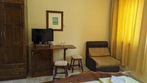 a bedroom with a desk and a tv and a chair at Prima Vera Hotel in Primorsko