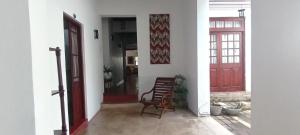 pasillo con silla y puerta roja en Kaya Residence Kandy, en Kandy