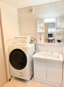 a laundry room with a washing machine and a sink at ＊大阪＊一棟貸切、駅から徒歩3分、複数駅利用可、電車で梅田まで5分、地下鉄でなんばまで9分 in Osaka