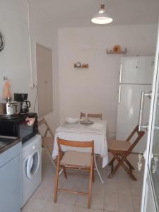 cocina pequeña con mesa, sillas y fogones en Argyro's vintage House en Spílion