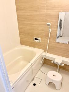 a bathroom with a bath tub and a toilet at ＊大阪＊一棟貸切、駅から徒歩3分、複数駅利用可、電車で梅田まで5分、地下鉄でなんばまで9分 in Osaka