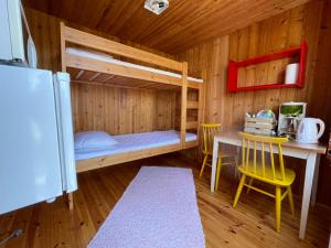 Kolmiloukon leirintäalue في Taivalkoski: غرفة نوم مع سرير بطابقين وطاولة وكراسي