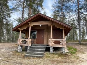 a small log cabin with stairs in a forest at Kolmiloukon leirintäalue in Taivalkoski