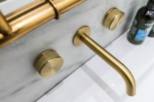 a bathroom counter with gold handles and a sink at Malvern - By Luxury Apartments in Cheltenham