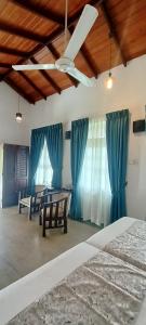 Kaya Residence Kandy في كاندي: غرفة نوم بسرير ومروحة سقف