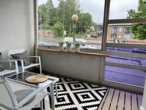 a balcony with chairs and a table and a window at Kotimaailma Apartments near center apartment+sauna in Lahti