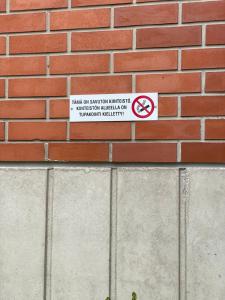 a no smoking sign on a brick wall at Kotimaailma Apartments near center apartment+sauna in Lahti