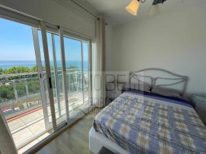 a bedroom with a bed and a view of the ocean at BV-ST-010-Apartamento Can Villa in San Pol de Mar