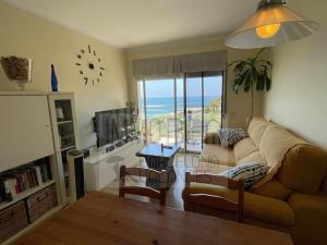 a living room with a couch and a view of the ocean at BV-ST-010-Apartamento Can Villa in San Pol de Mar