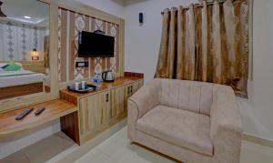 a living room with a chair and a television at Treebo Trend Seven Inn in Tirupati