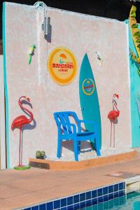 uma placa com uma cadeira e uma prancha de surf ao lado de uma piscina em MANDARIN LODGE by victor em Hua Hin
