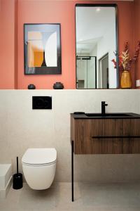 y baño con aseo, lavabo y espejo. en Villa L'Anse - 1er étage en Étretat