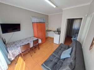 a living room with a couch and a table at Woodhills Guest house in Piet Retief