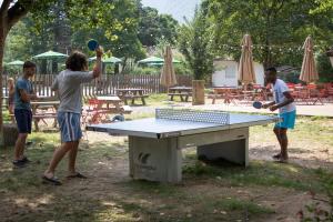 un groupe de personnes jouant au tennis de table dans l'établissement Huttopia Millau, à Millau