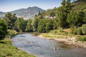 a group of people swimming in a river at Huttopia Millau in Millau