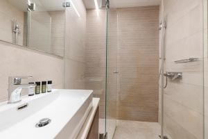 een badkamer met een wastafel en een glazen douche bij Phaedrus Living: Executive Flat Kolonaki in Athene