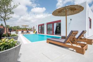 a swimming pool with a chair and an umbrella at SunDaLucky in Afantou