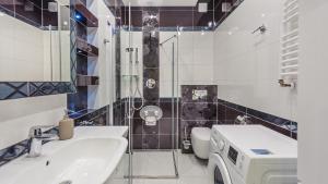 a bathroom with a sink and a washing machine in it at Apartamenty Sun & Snow Willa Park in Dziwnów